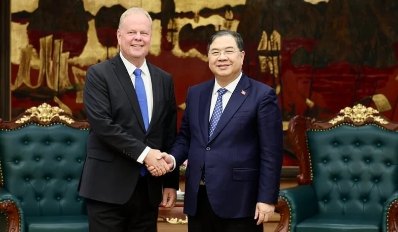 Representatives of Siemens Energy and Vietnam shake hands at a meeting.